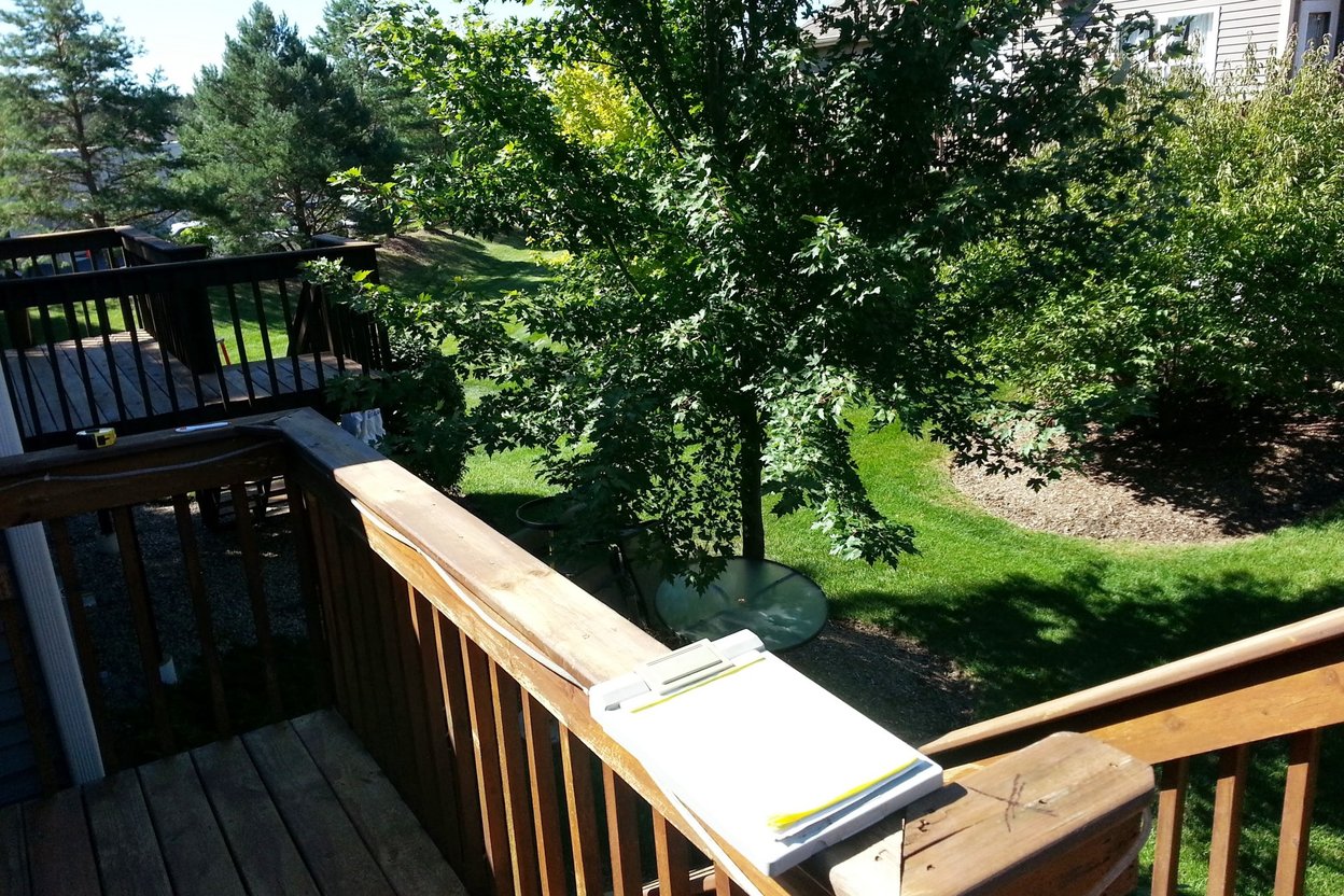 A contractor and crew member reviewing a printed, signed work order on a clipboard at a home renovation job site.