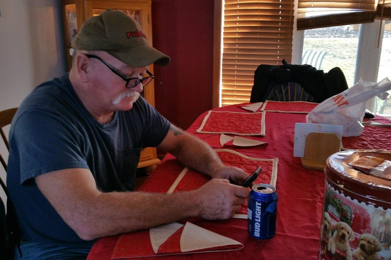 A tradesman at dinner with his phone lighting up