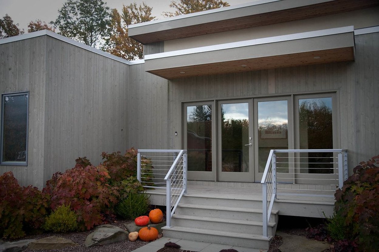 Close-up photo of a finished exterior repair showing new trim around a door or completed siding work, without any faces or house address visible.
