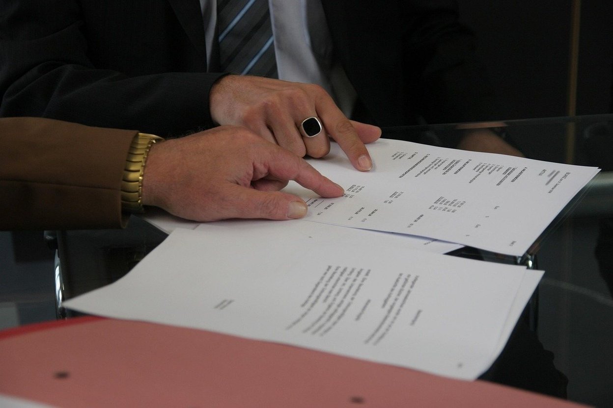 A franchise disclosure document opened on a truck tailgate, with a calculator and a work van carrying a national brand's logo in the background